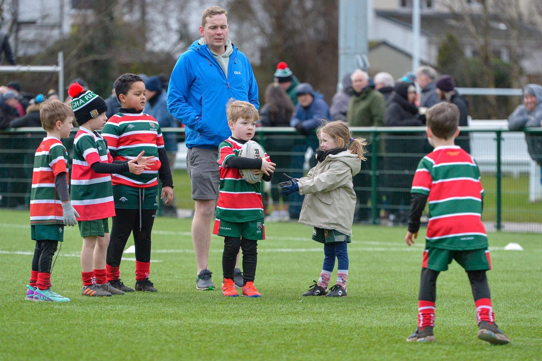 Two GHA minis players standing on the pitch with a rugby ball